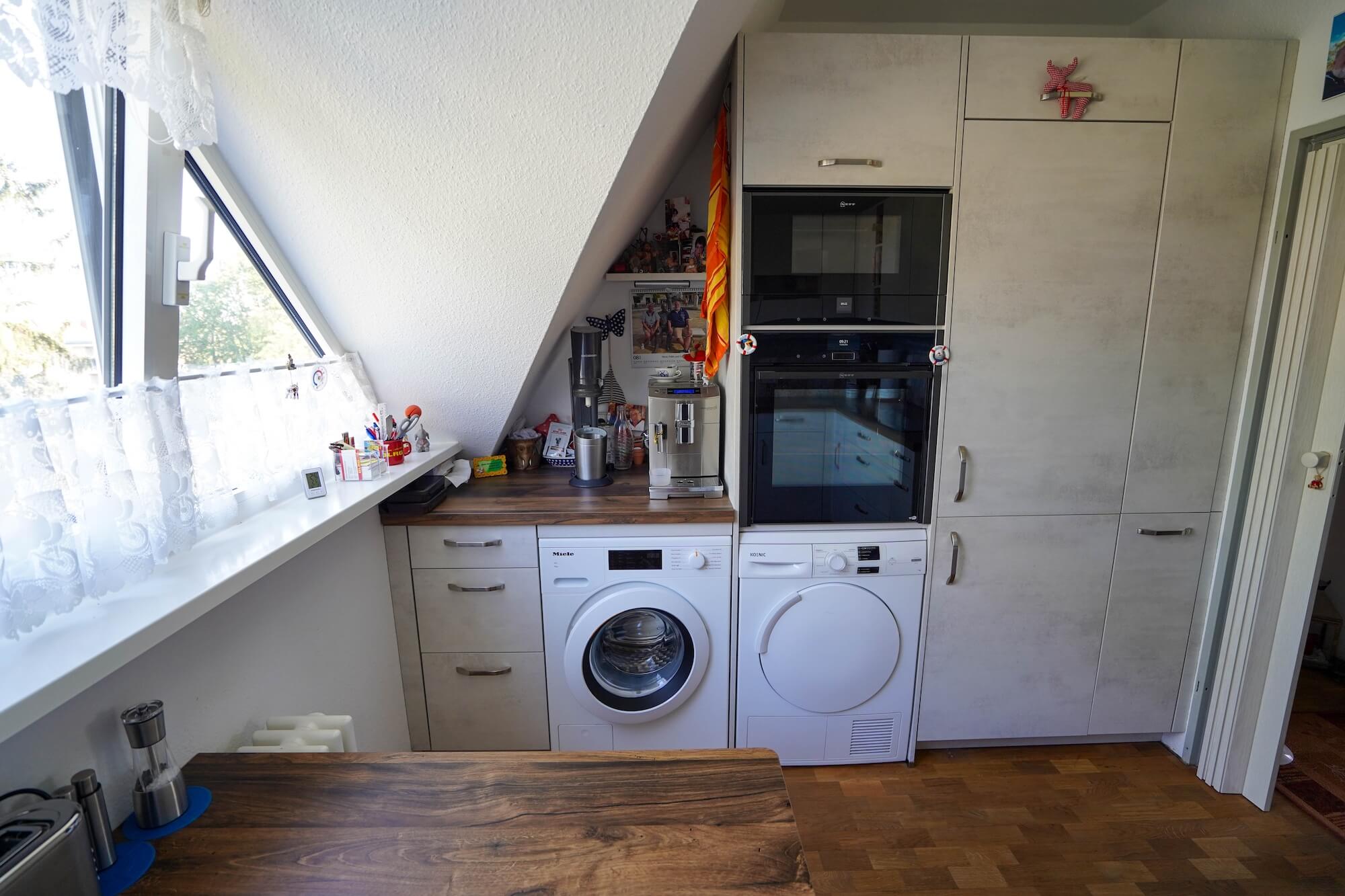 Klassische L-Küche mit Hochschrank und Esstisch nah