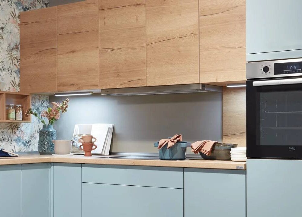 Kochbereich der Nobilia Moderne L-Küche aqua mit Flachschirmhaube und Backofen auf Arbeitshöhe