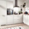 Nobilia Moderne L-Küche magnolia mit zwei Hochschränken, Kaminhaube und Arbeitsplatte in Eiche-Optik